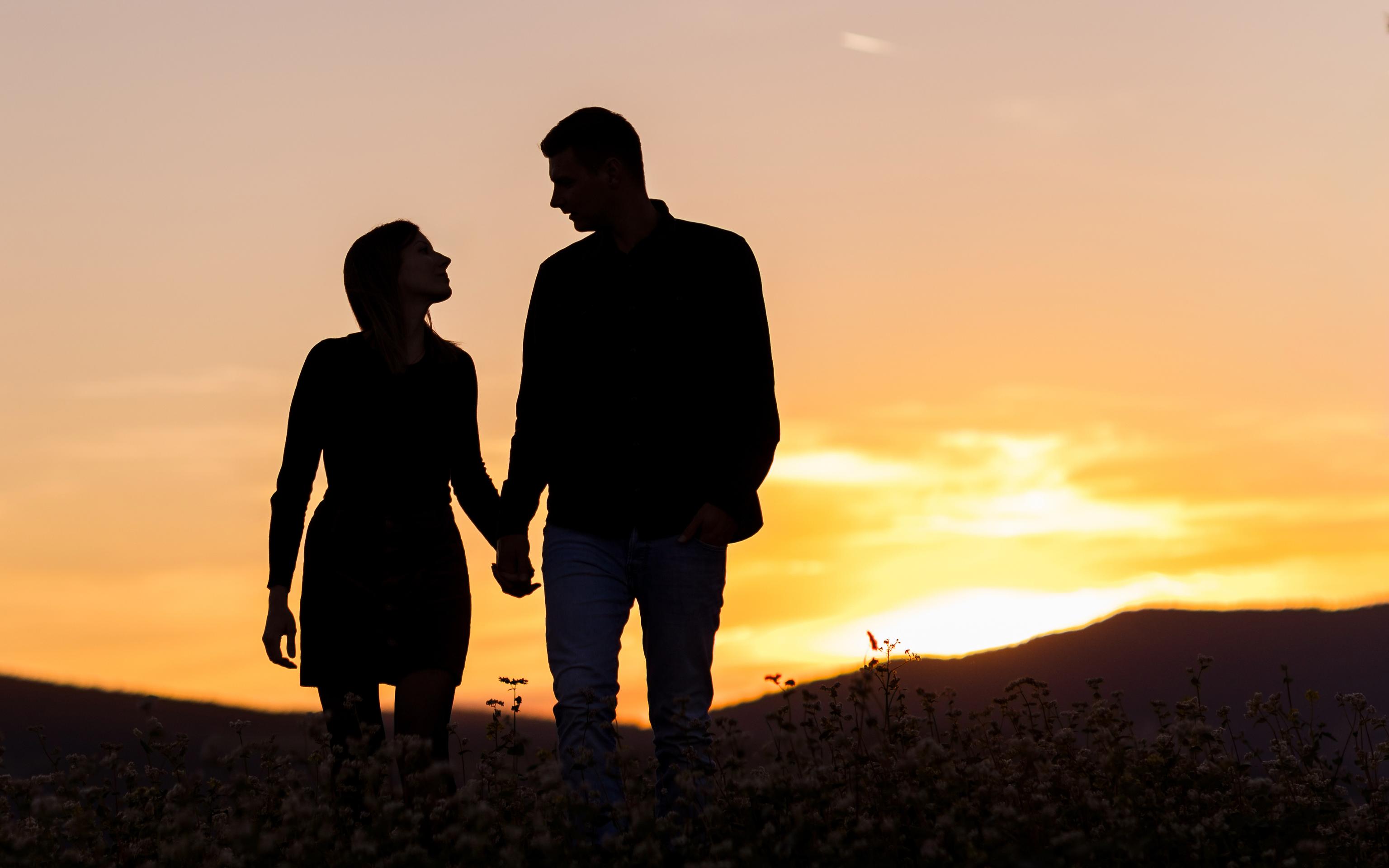 Schwarz-weiß Bild von zwei Frauen mit Lederhüten die sich lächelnd ansehen.